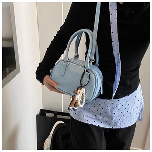 Light blue patent leather mini bowling bag with pearl chain and detachable strap on model