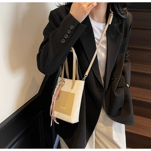 Vertical off-white leather phone bag with brown pocket and pink braided pendant charm