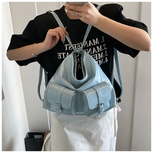 Mirror selfie showing a light blue shiny faux leather tote bag with pocket details
