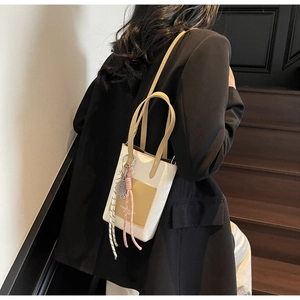 Lifestyle view of white and yellow crossbody phone bag with tennis racket charm