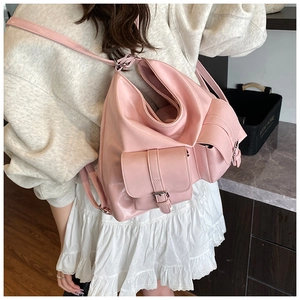 Detail of pink faux leather tote bag with front buckle pockets and adjustable straps