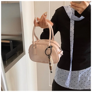 Pink patent leather Boston handbag with decorative pearl charm and top handles