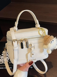 Minimalist white litchi leather box bag with dual zippers and cute plush doll charm