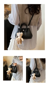 Detalle de bolso cubo de cuero negro con cierre giratorio plateado y colgante de oso de peluche
