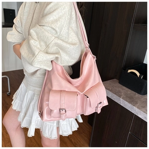 Detail of pink hobo bag featuring glossy PU leather surface and front flap pockets
