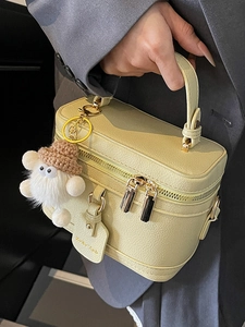 Minimalist cream yellow box handbag with lychee texture and plush monster charm