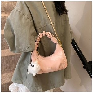 Pink pleated dumpling bag with gold chain strap and cute plush charm detail view