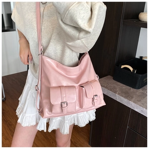 Detail of light pink large capacity tote bag featuring double front buckle pockets