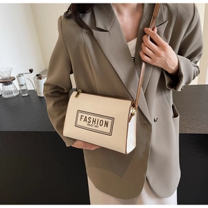 Detail of cream shoulder bag with Fashion Enjoy Art print and brown leather strap
