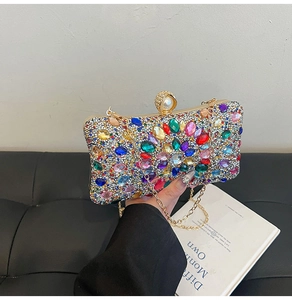 Detail of colorful gemstone evening clutch bag with pearl clasp and gold chain strap