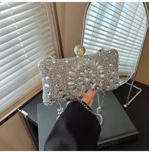 Detail of luxury silver clutch with radial rhinestone floral pattern and pearl clasp