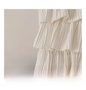 Vue macro des volants superposés et du tissu crème doux avec un lustre soyeux