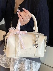 Creamy white patent leather Boston bag with embossed letters and pink lace ribbon