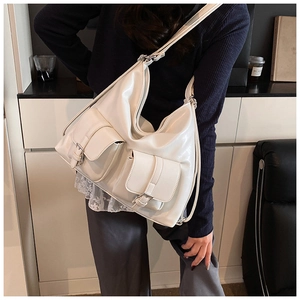 Detail view of large cream-white tote bag with double pockets and vintage buckles