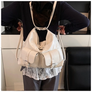 Detail of white PU leather tote with double pockets and silver metal buckles