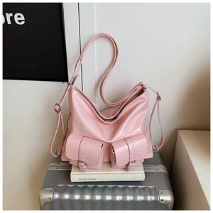 Pink PU leather tote bag with functional pockets displayed on a silver travel suitcase