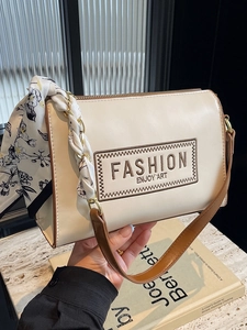 Stylish cream leather shoulder bag with brown trim and floral scarf detail for women