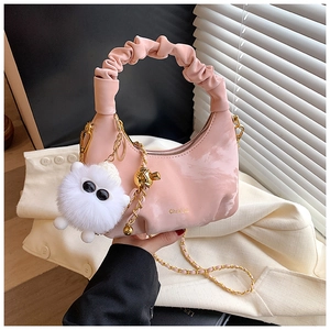 Pink pleated dumpling bag with golden chain strap and a white plush monster charm