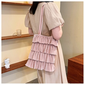 Détail du sac à bandoulière rose à volants étagés avec chaîne en perles élégante