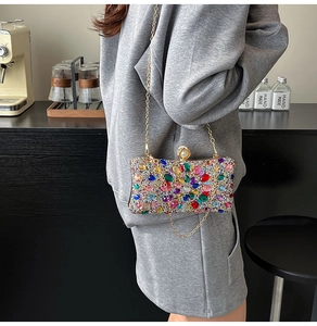 Detail of colorful rhinestone evening clutch bag with sparkling floral pattern and chain
