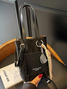Fashionable black tote bag with wrinkled leather texture and stylish tennis racket pendant