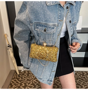 Detail of luxury gold rhinestone evening clutch with pear-shaped gems and pearl clasp