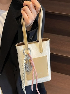 Minimalist vertical mobile phone bag with contrast pocket and tennis racket charm
