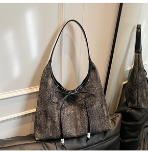 Dettaglio della borsa hobo con paillettes, fiocco nero e perline per un look di moda