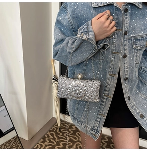 Detailed side view of silver rhinestone luxury clutch bag with crystal flower and pearl clasp