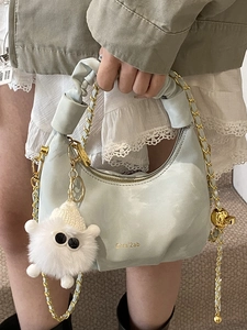 Light blue pleated crescent bag with cloud handle and cute plush monster charm