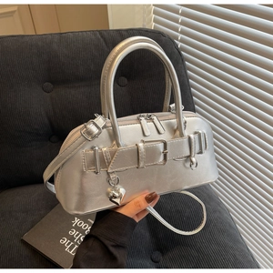 Détail du sac à main argenté métallisé avec breloque coeur et boucles de ceinture chic