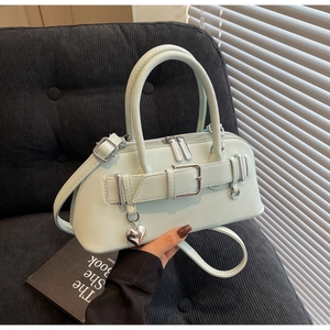 Détail du sac à main vert menthe avec boucle argentée et pendentif en forme de cœur