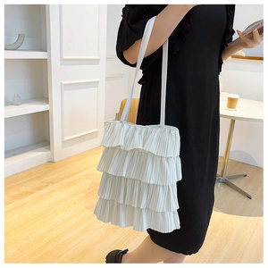 Détail du sac cabas blanc à volants avec plis délicats et bandoulière élégante