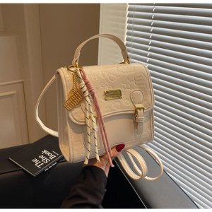 Détail du petit sac carré gaufré blanc crème avec motifs et quincaillerie dorée
