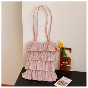 Gros plan sur les volants superposés rose clair et la texture douce de ce sac à bandoulière