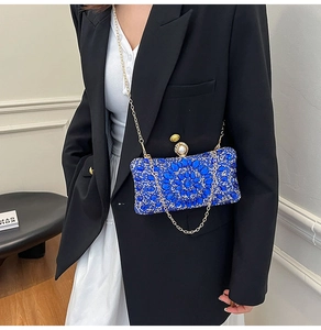 Detailed macro view of royal blue luxury clutch featuring crystal rhinestones and pearl clasp