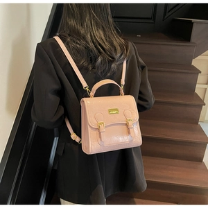 Mini sac à dos rose embossé porté sur le dos, avec rabat à boucles et fines bretelles