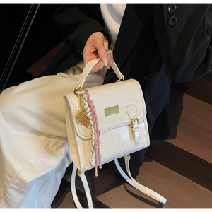 Détail du sac à main crème avec motifs en relief et accessoires en métal doré