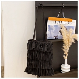 Vue détaillée du design plissé multicouche sur ce sac à bandoulière noir élégant