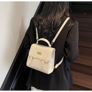 Détail d'un mini sac à dos blanc crème avec gaufrage fleurs love et boucles dorées