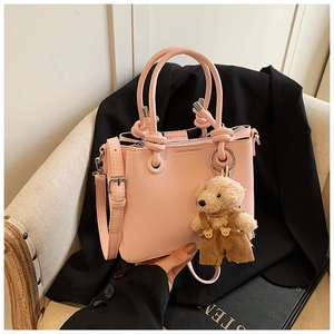 Roze bucket bag met lychee textuur, knoophendel en een schattige beer sleutelhanger