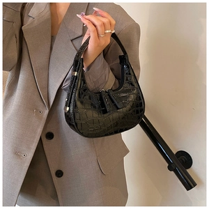 Detail shot of black crocodile embossed patent leather crescent hobo bag for women
