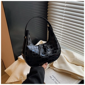 Detailed close-up of a black croc-embossed crescent underarm bag with glossy leather texture