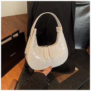 Close-up of creamy white faux crocodile skin texture and zipper on crescent bag
