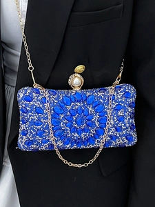 Luxury navy blue evening clutch bag with sparkling crystals and pearl clasp on a gold chain