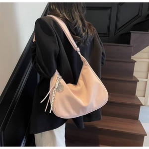 Detailed view of pink leather hobo bag featuring adjustable strap and silk scarf accent