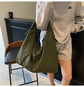 Detail of olive green slouchy tote bag showing durable nylon texture and drawstring side
