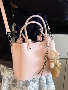 Roze emmer handtas met getextureerd leer en een schattige pluche beer hanger eraan