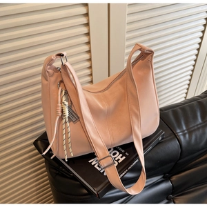 Detail of soft pink PU leather tote with dual straps, knot charm and metal zipper