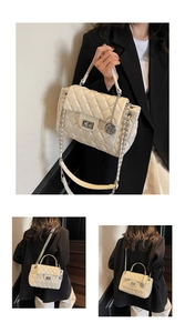 Detail of creamy white quilted handbag with silver clasp and chain strap on black blazer